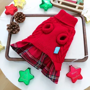 Detailaufnahme rotes Weihnachts-Haustierkleid mit Schottenmuster auf Holztablett