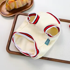 Detail of cream ribbed pet vest with red and black striped trim and brand label