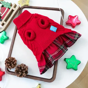 Detail eines roten Zopfstrick-Hundepullovers mit klassischem Karo-Faltenrock für Weihnachten