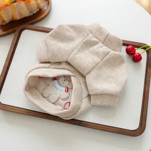 Détail du pantalon pour animaux en tricot côtelé beige avec broderie d'ours et poignets