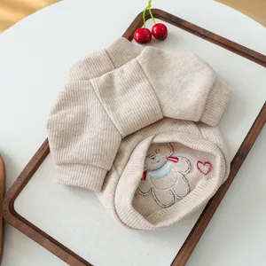 Gros plan détaillé du pull beige pour animaux en tricot côtelé avec broderie d'ours