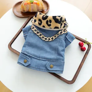 Detalle de chaqueta vaquera para mascota con cuello de leopardo y cadena de oro decorativa