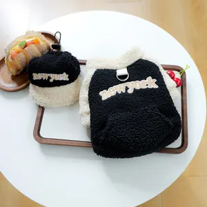 Close-up of black fleece pet vest and hat set with New York embroidery on wood tray