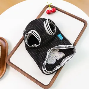 Detail of pet jersey with number 25 embroidery and striped fabric on wooden tray