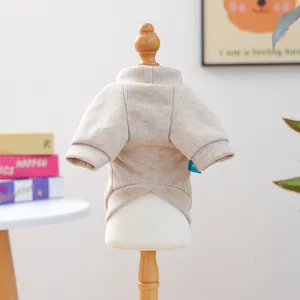 Détail d'un pull pour animal en tricot beige avec col rond et texture en maille côtelée