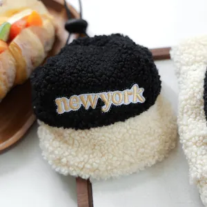 Close-up of fluffy black and beige sherpa pet bucket hat with New York gold embroidery