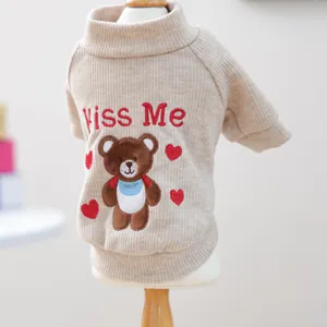 Détail d'un pull en maille côtelée beige pour animaux avec broderie ours et cœurs