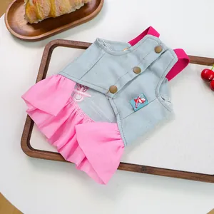 Close-up of pink ruffled pet dress with blue denim fabric and vintage buttons decoration