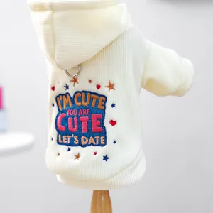 Detailaufnahme von cremefarbenem Hunde-Hoodie mit bunter Stickerei und Metall-D-Ring-Element