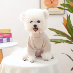 Détail d'un pull beige côtelé pour animal sur petit chien blanc en intérieur