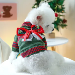 Nahaufnahme von grünem Haustier-Strickpullover mit festlicher Schleife und Schneeflocken