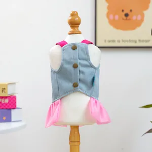 Detail view of pet denim dress featuring pink ruffled skirt and decorative buttons on mannequin