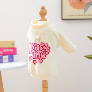 Detail of cream knit dog sweater with pink Kiss me embroidery and leash D-ring