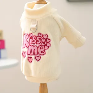 Detail of cream dog sweater with pink Kiss me embroidery and metal D-ring attachment