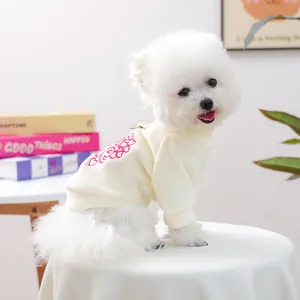 Close-up of cream ribbed knit pet sweater with pink heart embroidery and raglan sleeves