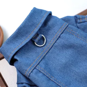 Détail de gilet pour animaux en denim bleu avec surpiqûres orange et anneau en D en métal