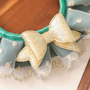 Détail de collier pour animaux vert avec nœud à paillettes dorées et dentelle de tulle