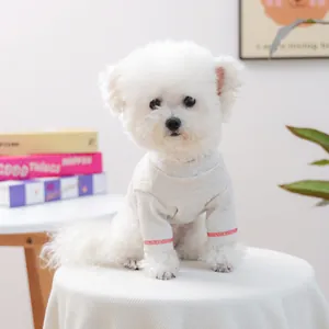 Détail d'un pull en tricot gris clair pour animaux avec coutures rouges aux poignets