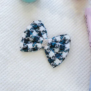 Détail d'un nœud papillon en tweed pour animaux avec perles sur fond blanc doux