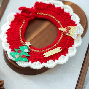 Detail van rood-wit gehaakte slabbetje voor huisdieren met kerstboombedeltjes