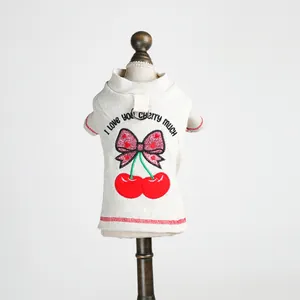 Pull pour chien en maille côtelée crème avec broderie cerise et anneau en D sur mannequin