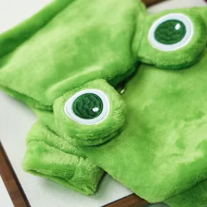 Close-up of green plush frog pet outfit showing soft flannel texture and embroidered eyes