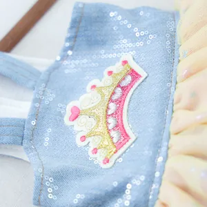 Détail d'une robe pour animal en jean bleu avec paillettes et broderie de couronne