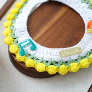 Detailed knit texture of a handmade pet collar with rainbow patches and metal tag