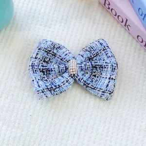 Gros plan d'une barrette nœud en tweed bleu pour animaux avec perle et strass chic