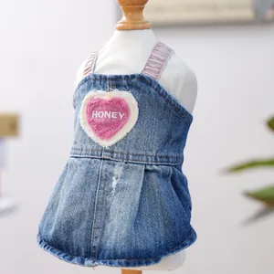 Dettaglio dell'abito in denim azzurro per cani con ricamo honey a cuore su manichino