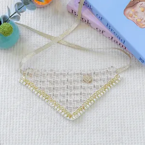 Detail of tweed pet bandana with pearls, lace edges, and a golden heart ornament