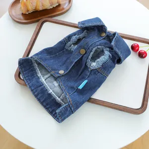 Detail of blue denim pet vest featuring vintage bronze snaps and frayed hem accents