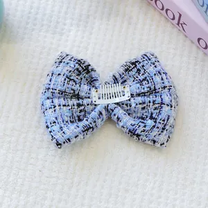 Détail d'une pince à cheveux en tweed pour petits animaux avec un peigne en plastique