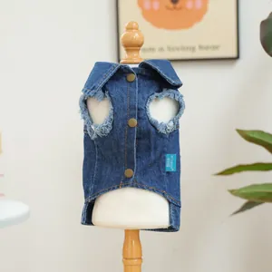 Detailed view of dark blue denim pet vest with bronze buttons and frayed sleeve edges
