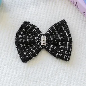 Détail du nœud en tweed noir et blanc pour animaux avec perles et strass étincelants