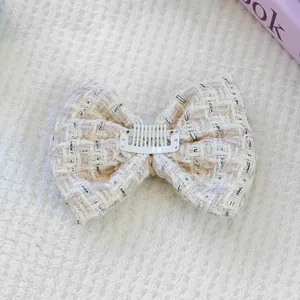 Detail of tweed bow hair clip with weave texture and comb attachment for pets