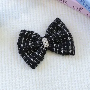Gros plan détaillé d'une pince à cheveux noeud en tweed avec perles sur fond peluche