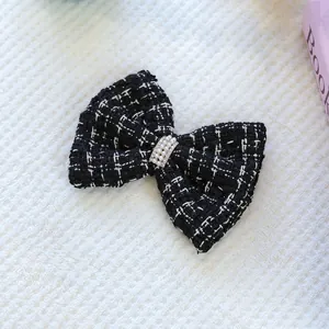 Gros plan d'une pince à cheveux en tweed avec perles sur fond de tapis blanc doux