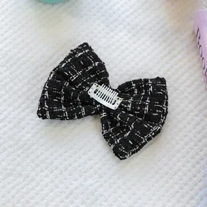 Gros plan du nœud papillon en tweed noir et blanc pour chien avec fixation clip BB