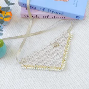 Λεπτομέρεια του tweed bandana κατοικίδιων με πέρλες και κουμπί καρδιά σε φόντο