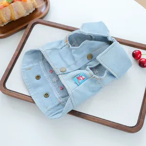 Close-up of light blue pet denim vest with metallic buttons and embroidery detail