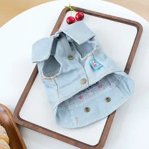 Detail of light blue denim dog vest with metal snap buttons and embroidered star flag tag