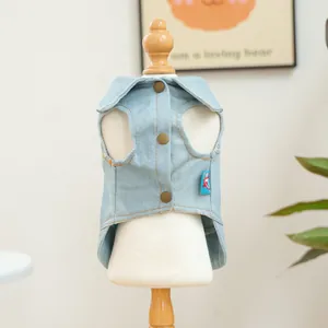Close-up of light blue denim pet vest featuring brown buttons and yellow stitching