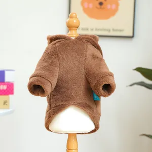 Close-up of brown plush owl pet hoodie texture on a small wooden mannequin stand