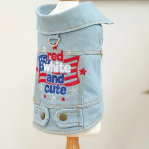 Close-up of light blue denim dog vest featuring flag embroidery and metal D-ring attachment
