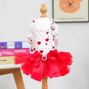Detail of pet dress featuring red hearts, white ruffles, and a large red bow decoration