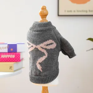 Detail of dark grey pet sweater featuring a large pink bow knit pattern and high collar