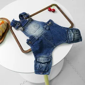 Close-up of pet denim overalls featuring metal buckles and side flap pockets on a tray