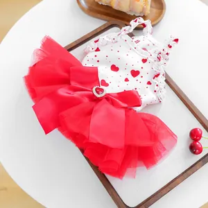 Detail of pet dress featuring a red silk bow with heart gemstone and layered mesh skirt