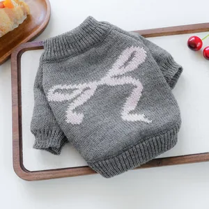 Gray knitted pet sweater with pink bow pattern on warm ribbed wool fabric